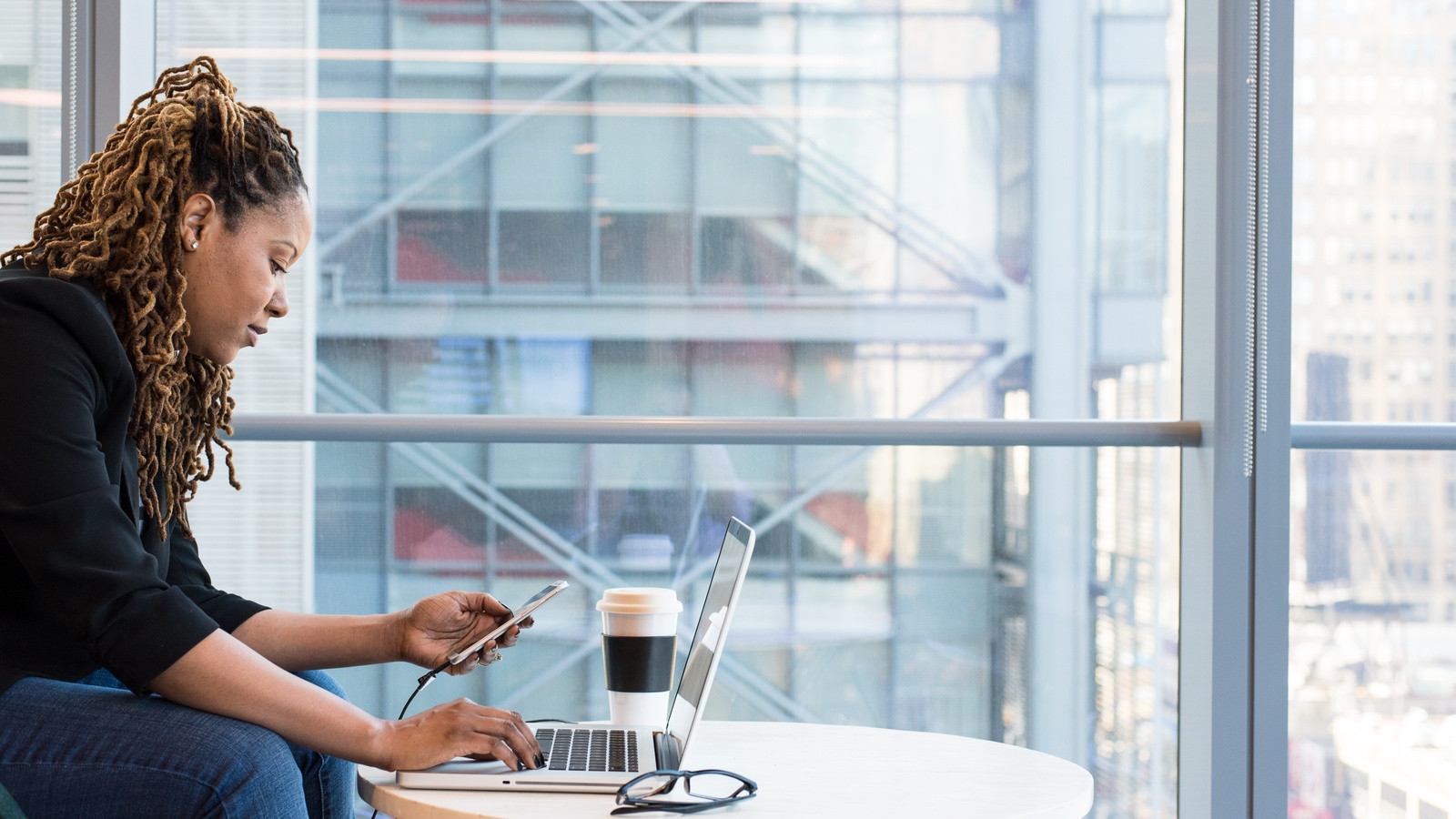 Customer support engineer and QA analyst reviewing a concise 20‑second screen recording on a large ultrawide monitor in a bright office, with natural window light and modern tech equipment.